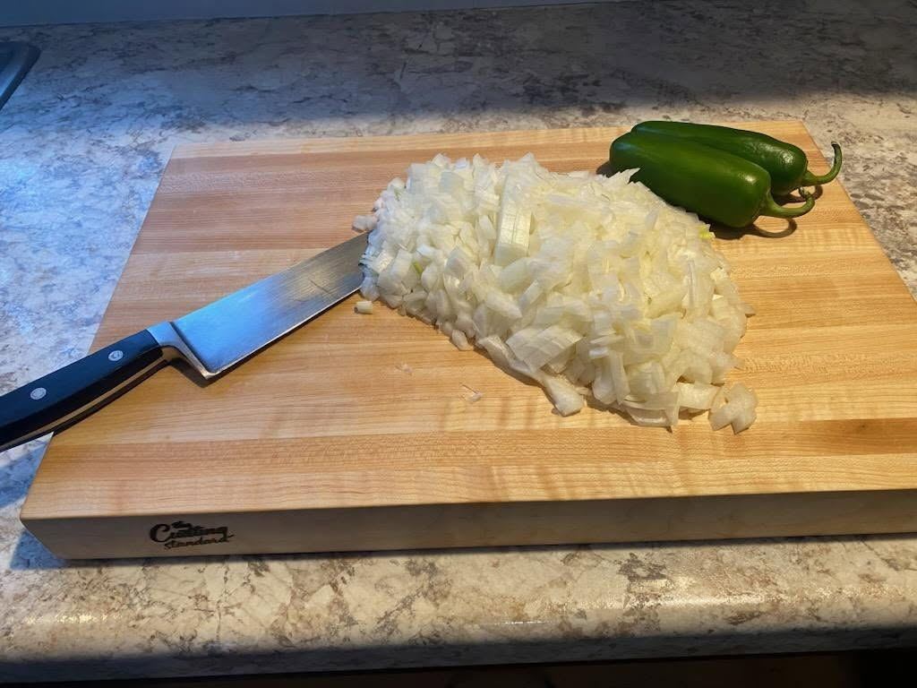 Maple cutting board in use with chopped onion and peppers