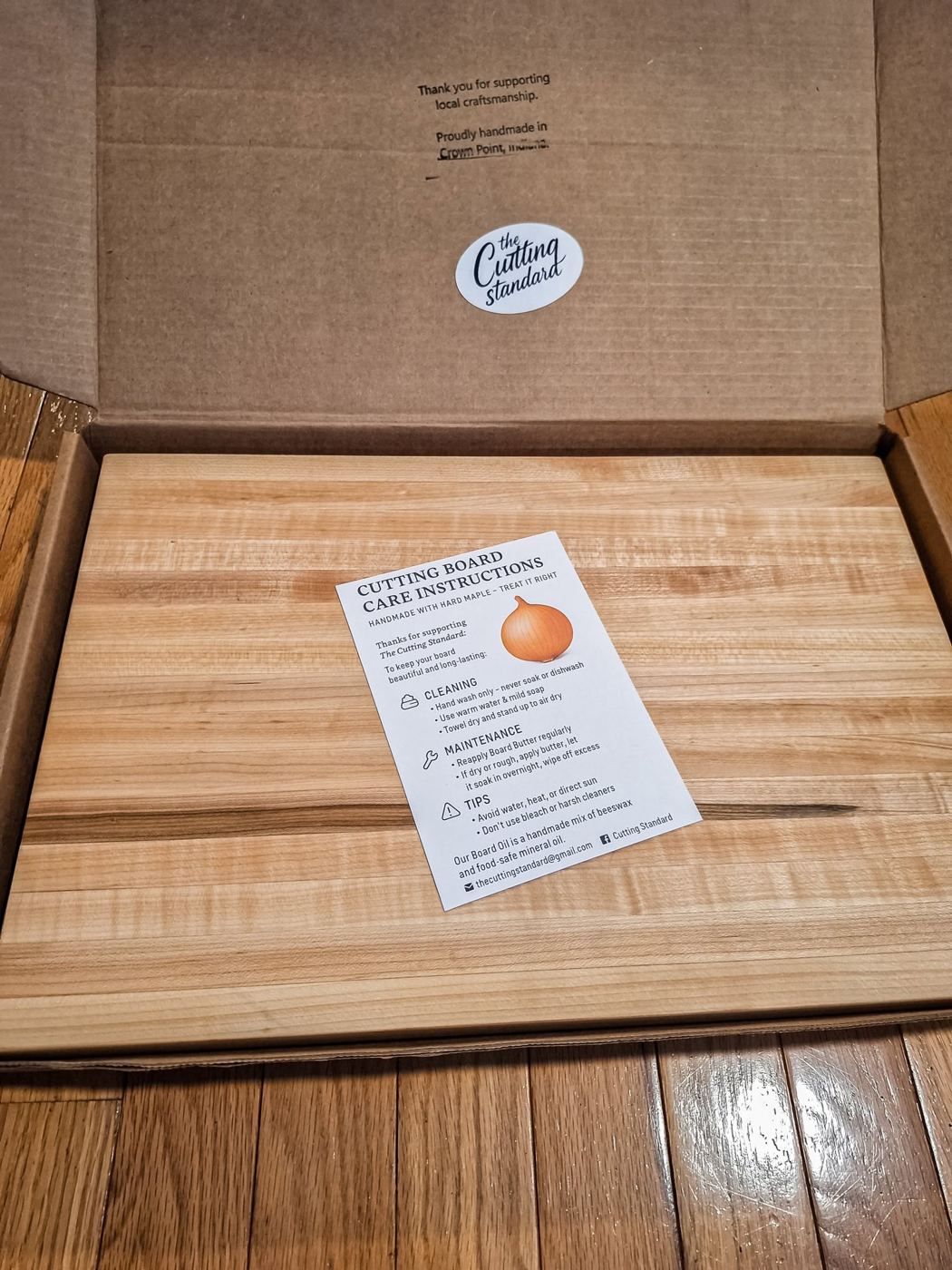 Board packaged in a kraft box with care instructions card